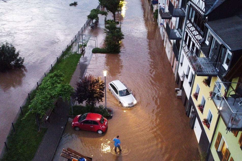 Autos versuchen auf einer überfluteten Straße vorwärts zu kommen. Die Mosel ist in dieser Woche in der Ortschaft Zell (Rheinland-Pfalz) über die Ufer getreten.