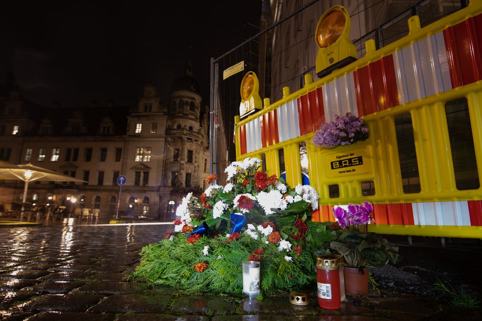 Blumen und Kerzen liegen an der Stelle in Dresden, an der zwei Touristen mit einem Messer von einem Islamisten angegriffen wurden. Dabei starb ein Mann.
