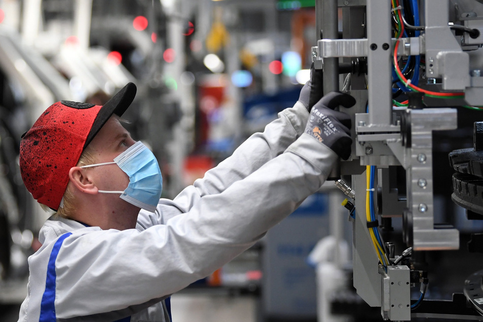 Ein Mitarbeiter von Volkswagen Sachsen arbeitet mit Mundschutz in einem Fahrzeugwerk in Zwickau.