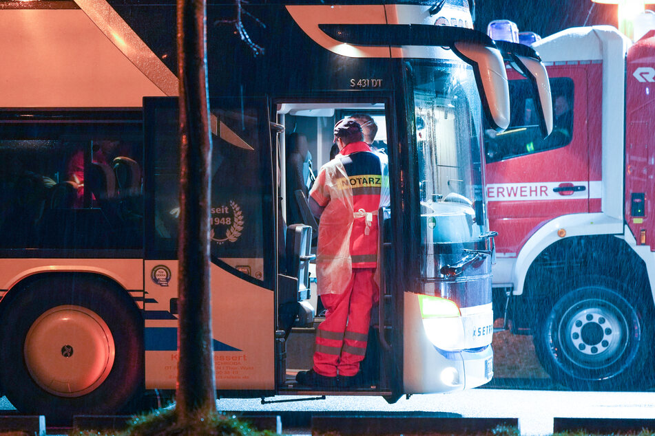 Ein Notarzt unterweist Schüler in einem Reisebus auf einem Schulgelände