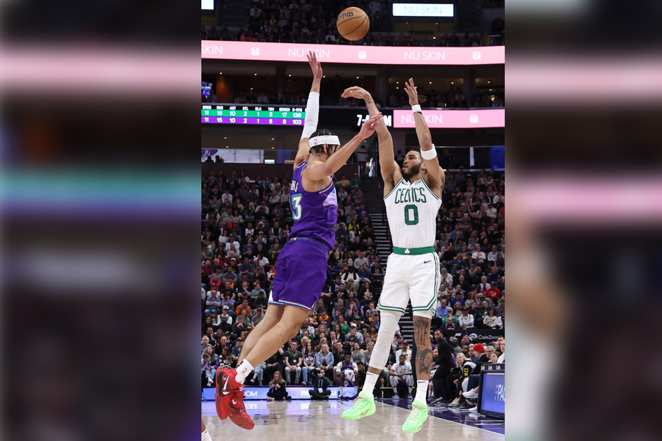 Boston Celtics forward Jayson Tatum (r.) shoots over Utah Jazz guard Johnny Juzang at Vivint Arena on Saturday night.