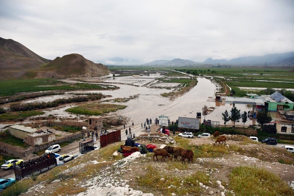 Afghan people gather along a road following a flash flood after a heavy rainfall in Feroz Nakhchir district of Samangan Province on May 11, 2024.