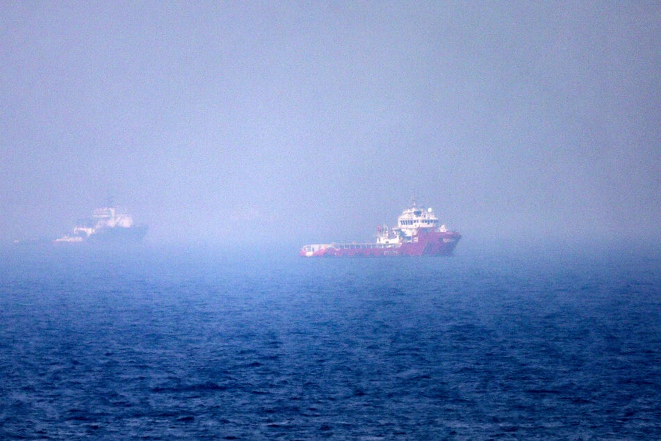 Ships sail near the Strait of Hormuz off the eastern coast of the United Arab Emirates at Khor Fakkan on July 13, 2026.
