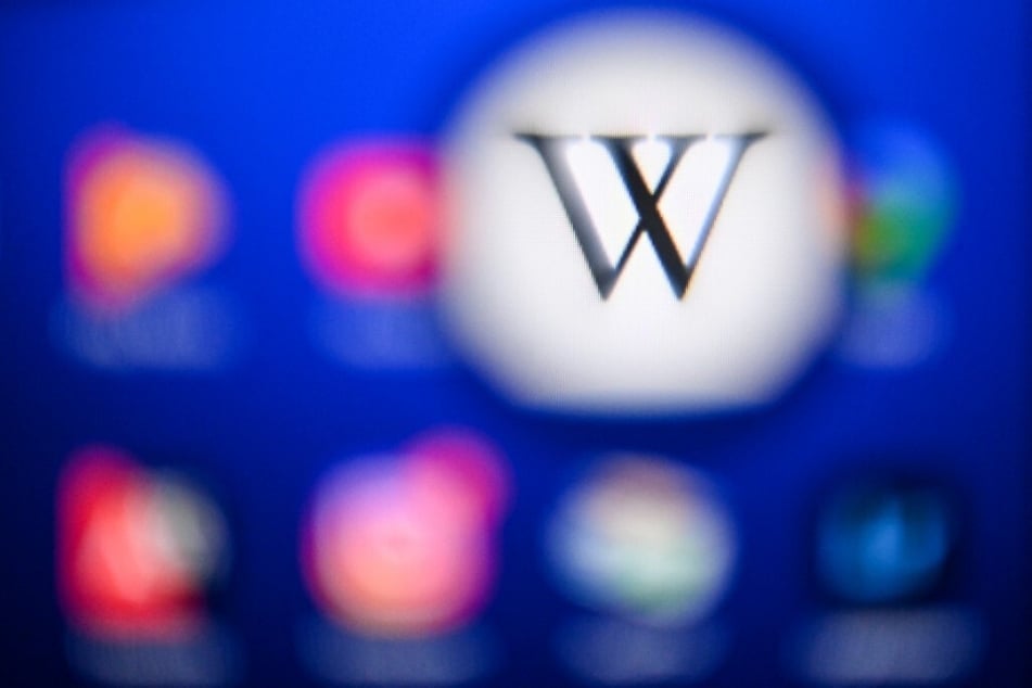 The Wikipedia logo is displayed on a tablet screen.