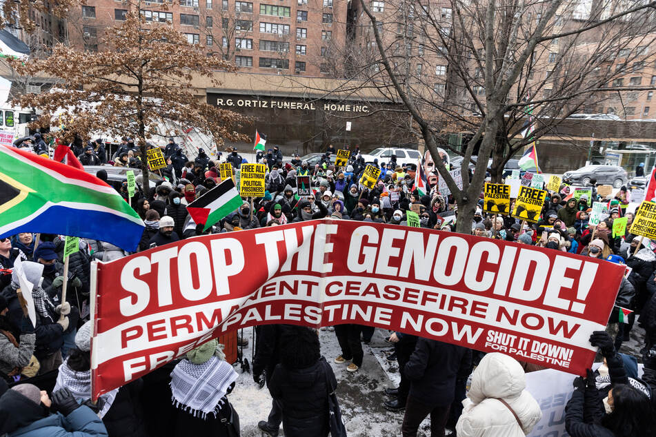 Demonstrators raise signs and banners as they take part in the "Biden: Stop Supporting Genocide!" rally in New York City on January 20, 2024.