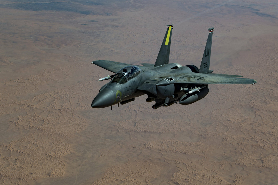 A US Air Force F-15E Strike Eagle fighter aircraft flies above the Iraqi desert.