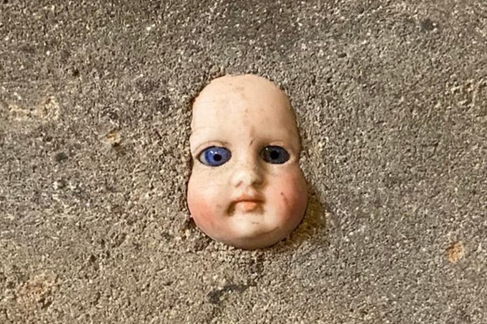 Why is this frightening doll's head stuck in the wall?
