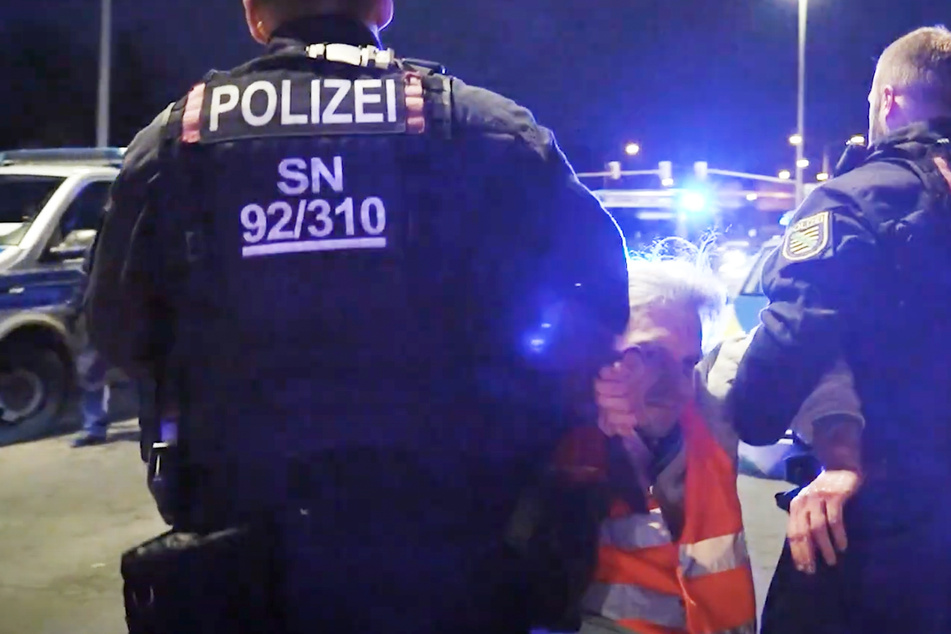 Christian Bläul (41) wird von Polizisten von der Straße getragen. Szene wie diese spielen sich häufig mit dem Aktivisten ab - nicht nur in Sachsen.