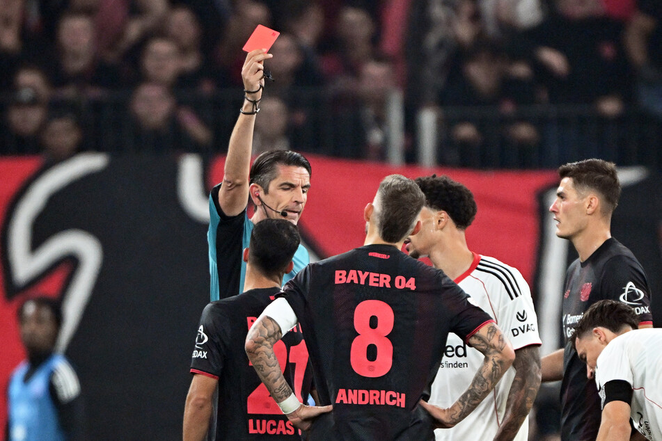 Deniz Aytekin (l.) schickte Robert Andrich (vorn) mit der Ampelkarte frühzeitig unter die Dusche.