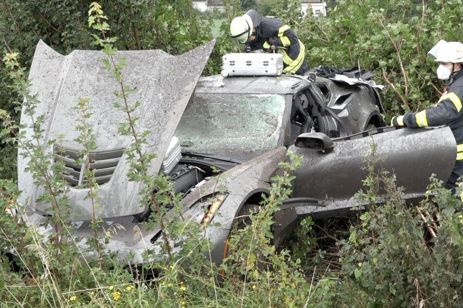 Das Bild zeigt das Wrack des Sportwagens in der Böschung neben der A67.