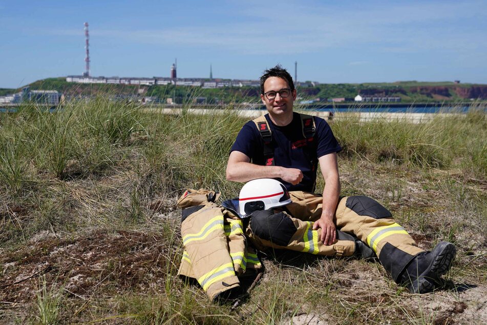 Felix Vorndran von der Freiwilligen Feuerwehr Bergisch-Gladbach sitzt an der Feuerwehrwache während seines Dünendienstes auf der Düne der Hochseeinsel Helgoland.