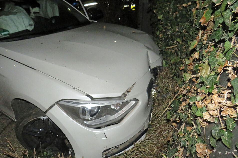 Der weiße BMW ist frontal mit einer getarnten Mülltonnenbox zusammengestoßen.