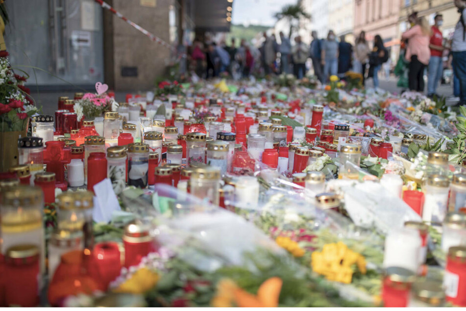 Blumen und Kerzen stehen vor dem Würzburger Kaufhaus, in dem ein 24-jähriger Mann in der vergangenen Woche mehrere Menschen getötet und verletzt hatte.