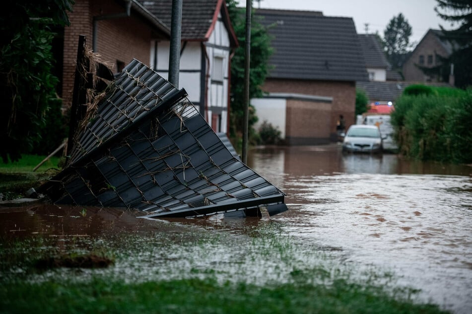 Ein Gartenzaun liegt im Wasser in Heimerzheim. Unwetter hatten am Mittwoch in Nordrhein-Westfalen und Rheinland-Pfalz ganze Landstriche verwüstet.