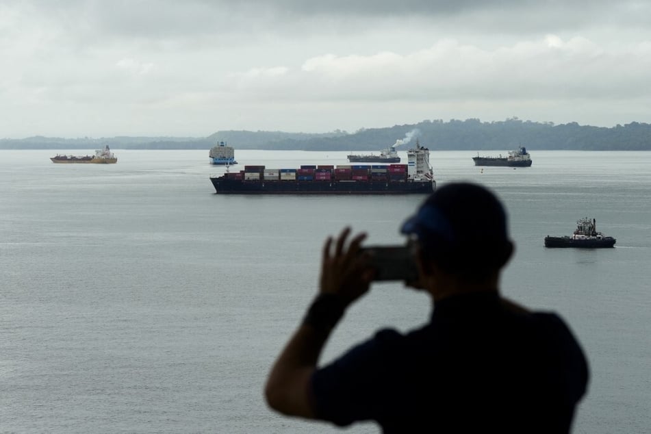 A tourist snaps a photo as a cargo ship sails through the Agua Clara Locks of the Panama Canal in Colon City on December 28, 2024.