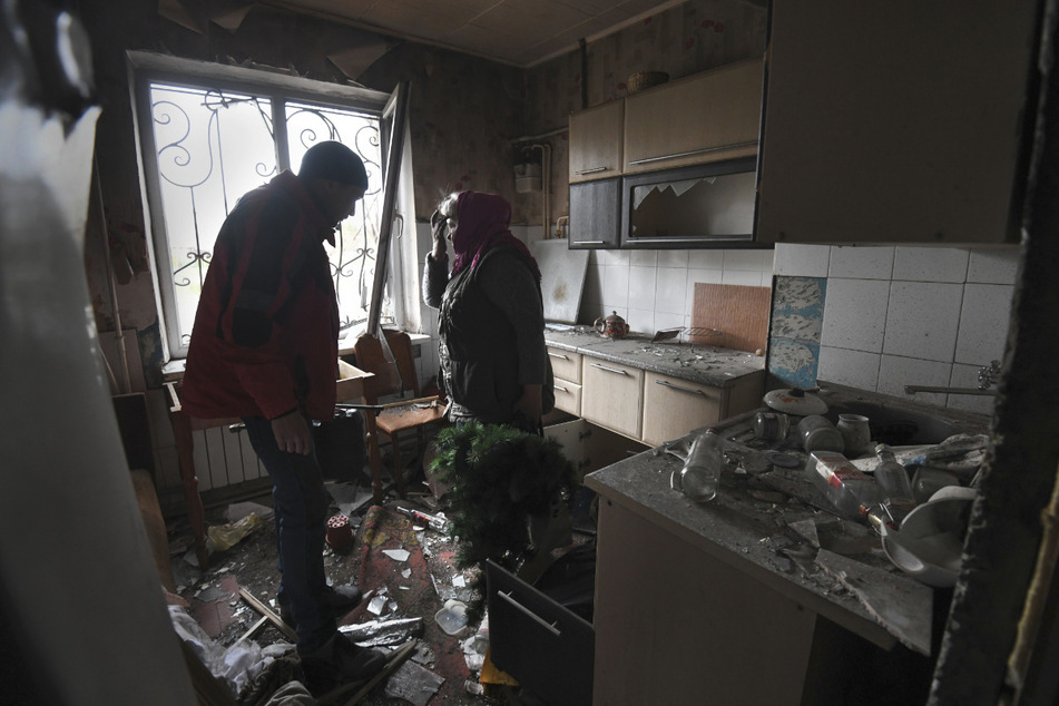 Natasha Kazmirenko (r) sammelt Habseligkeiten aus ihrer während der russischen Invasion zerstörten Wohnung ein. Sie wurde evakuiert und kehrte am 16. April zurück, um sich ein Bild von der Zerstörung zu machen und persönliche Gegenstände zu holen, die ihr noch geblieben sind.
