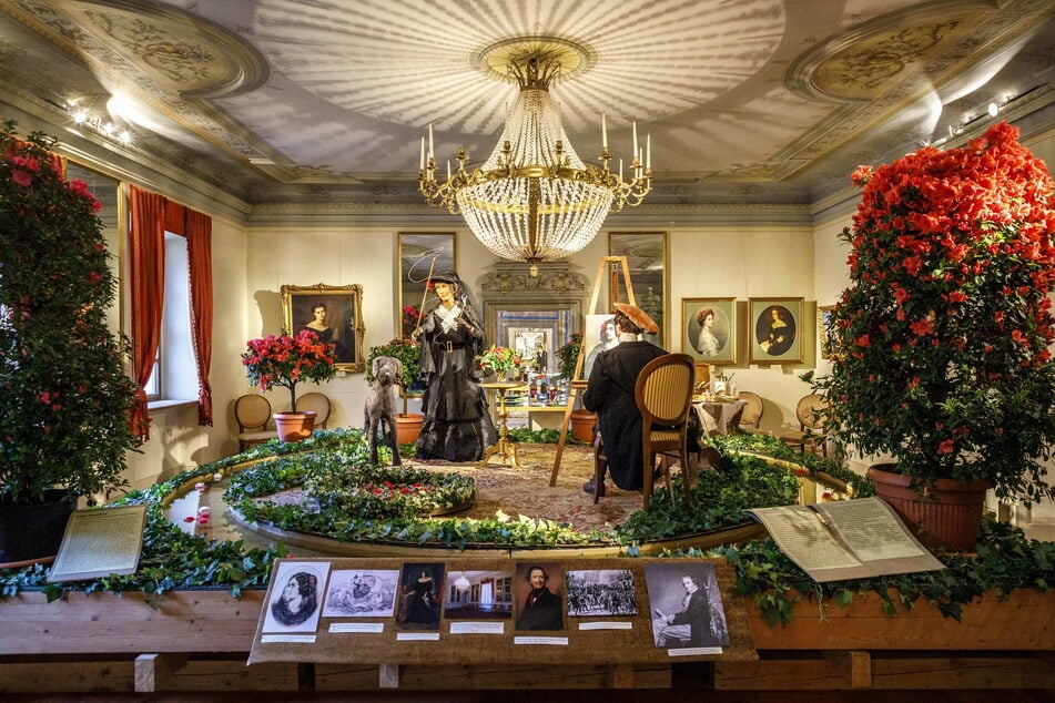 Mit einer Kamelie im Haar posiert Lola Montez dem Hofmaler Joseph Karl Stieler. Die Szene spielt auf die Schönheitsgalerie Ludwig I. an.