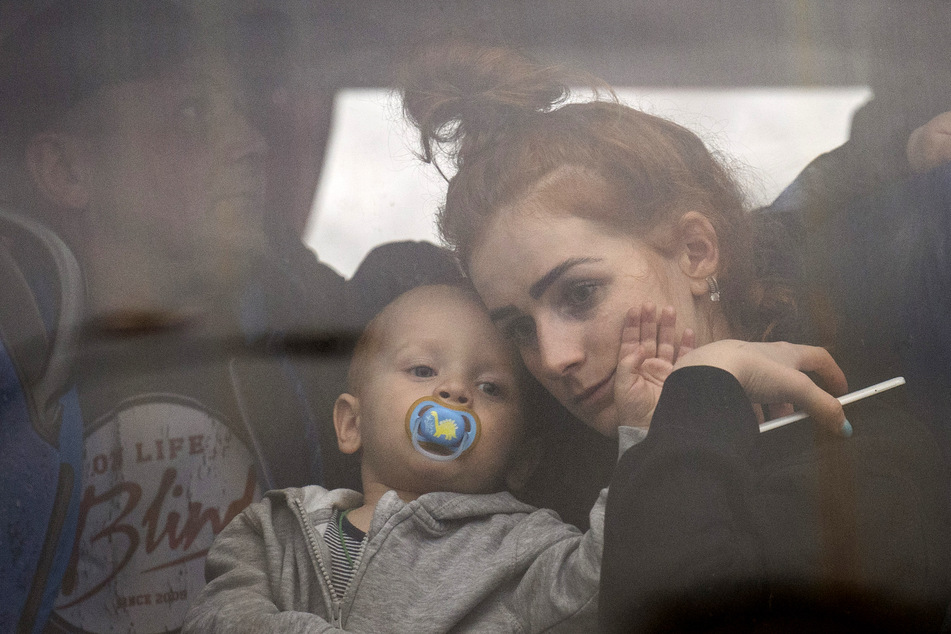 Eine Frau hält ihr Baby fest im Arm, während sie mit einem Bus die ukrainische Hauptstadt Kiew verlassen.