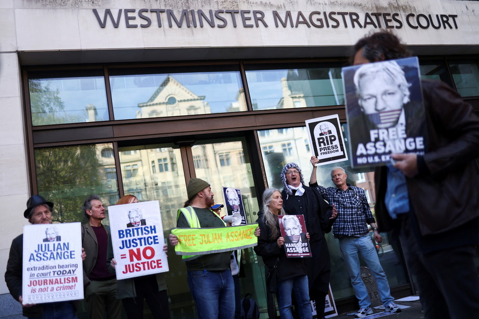 Supporters of Julian Assange display signs and banners outside the Westminster Magistrates' Court in London.