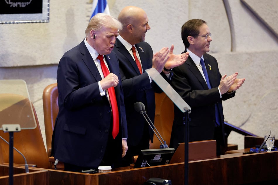 US President Donald Trump (l.) arrives to address the Knesset, with Speaker of the Israeli Knesset Amir Ohana (c.) and Israeli President Isaac Herzog, on October 13, 2025, in Jerusalem.