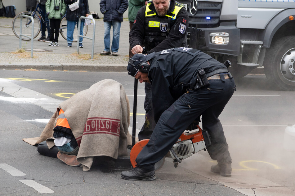 Die Polizei musste an den Asphalt geklebte Klimaaktivisten in Berlin von der Straße schneiden.