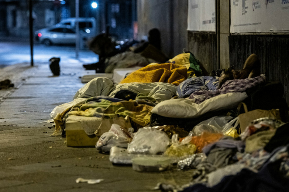 Obdachlose Menschen liegen unter einer Brücke in Berlin. (Archivbild)