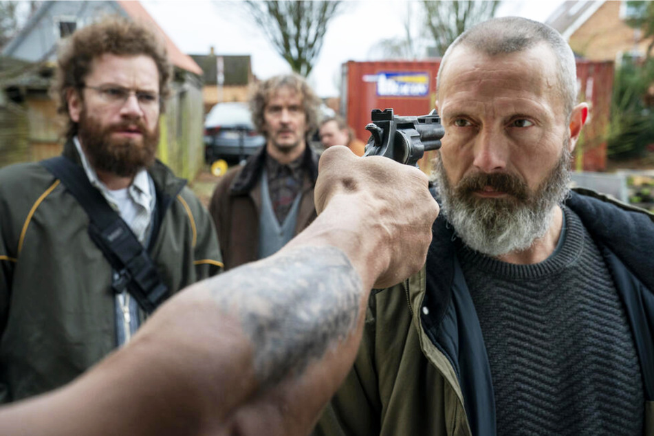 Markus (Mads Mikkelsen, 55, r.) lässt sich auch nicht von einer Pistole im Gesicht aus der Ruhe bringen. Als Soldat hat er dem Tod schließlich oft genug ins Auge geblickt.