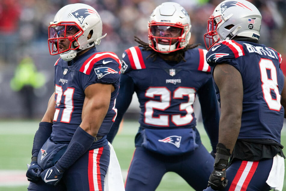 Patriots safety Adrian Phillips (l) celebrates with defensive back Kyle Duggar (c) and linebacker Ja Whaun Bentley (r).