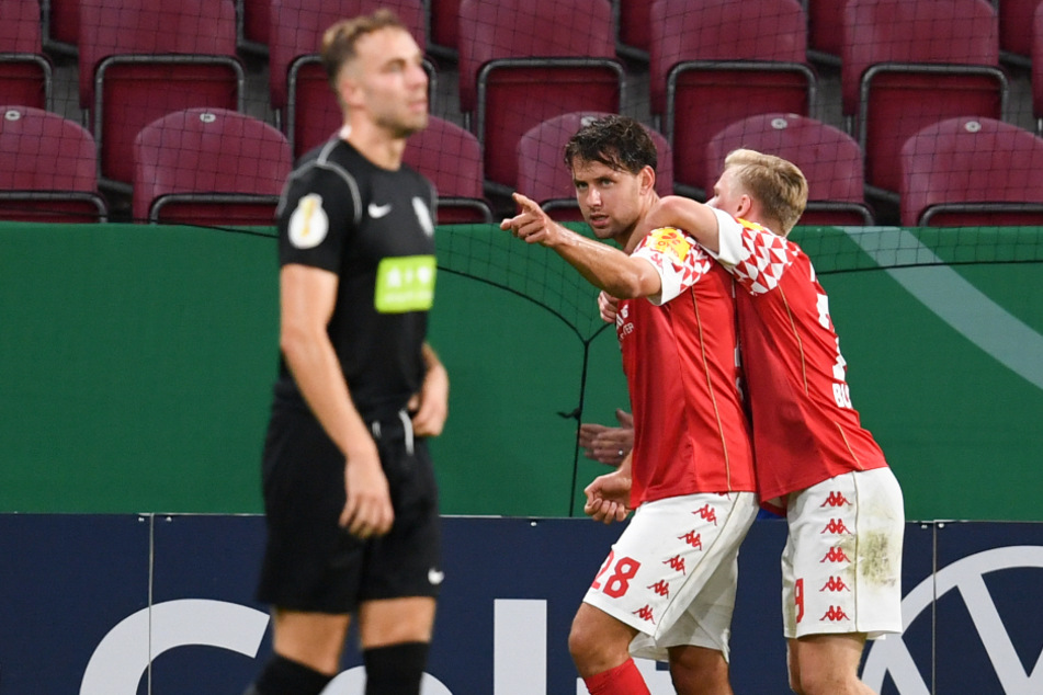 Die Mainzer Adam Szalai (M.) und Jonathan Burkhardt (r.) jubeln nach dem Tor zum 2:1 neben Julius Langfeld von Havelse.