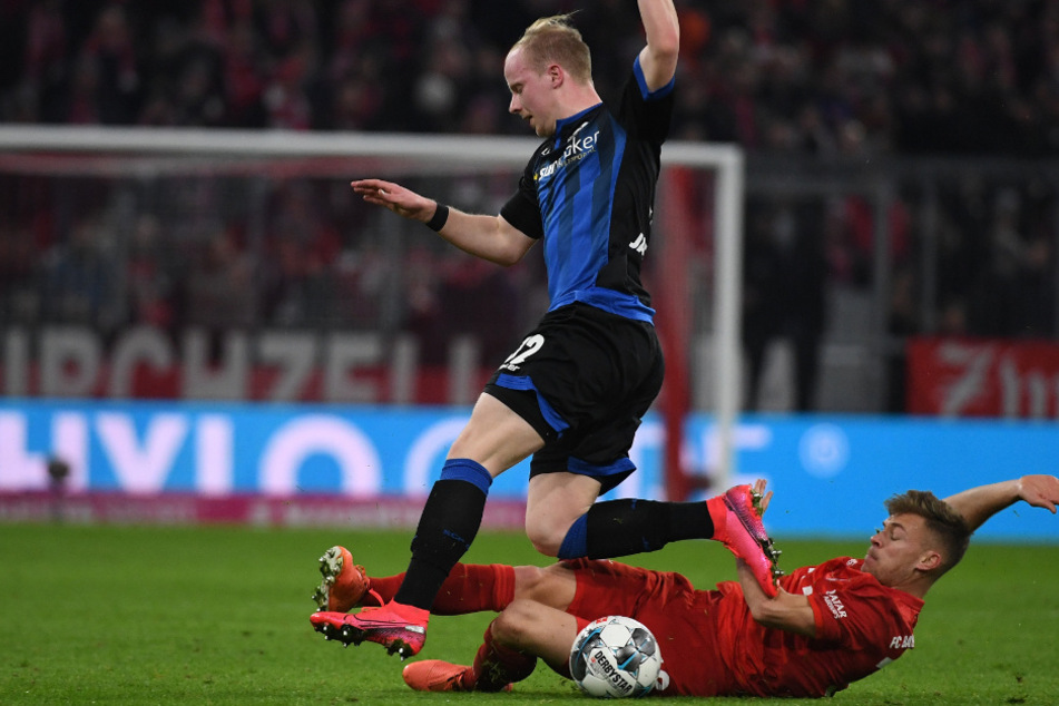 Bayerns Joshua Kimmich (r.) kämpft mit Paderborns Dennis Jastrzembski um den Ball.