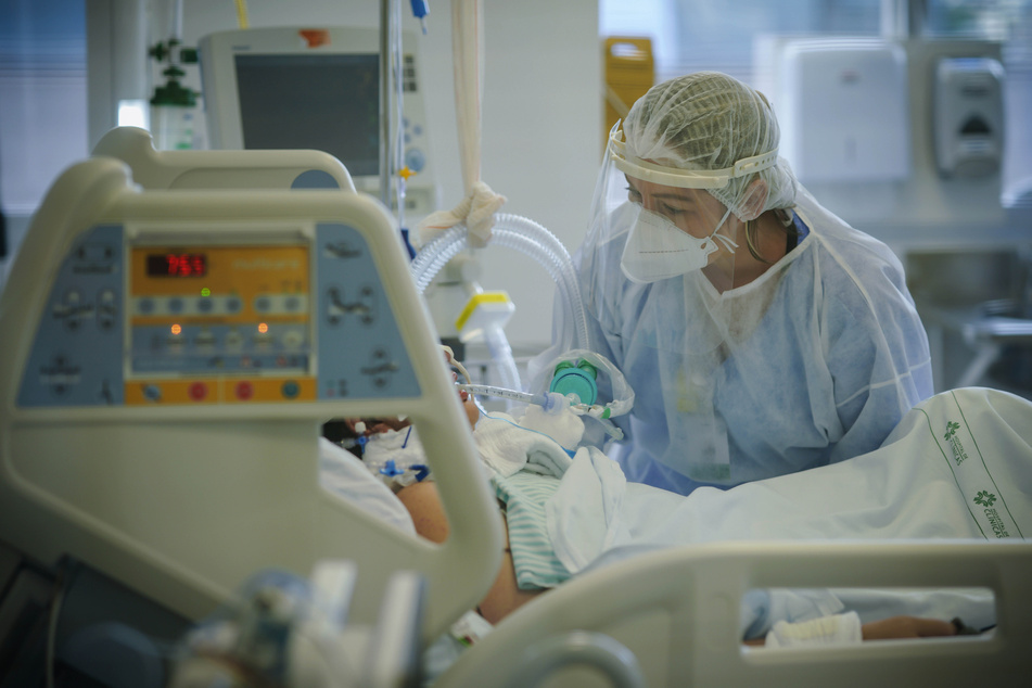 Eine medizinische Mitarbeiterin behandelt einen Covid-19-Patienten auf der Intensivstation.