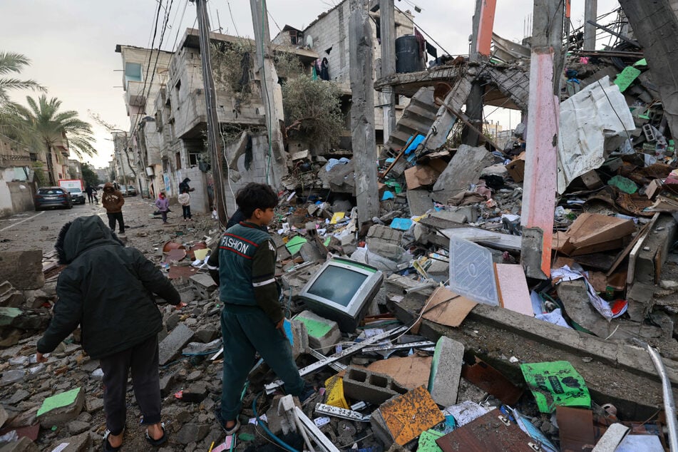 Children stand amid the rubble of a building destroyed by Israeli bombing in Rafah in the southern Gaza Strip on January 27.