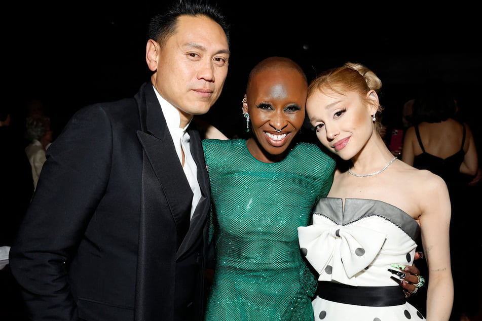 Wicked director Jon M. Chu (l.) recently revealed that Ariana Grande and Cynthia Erivo (c.) both sang live during filming of the Wicked movie.