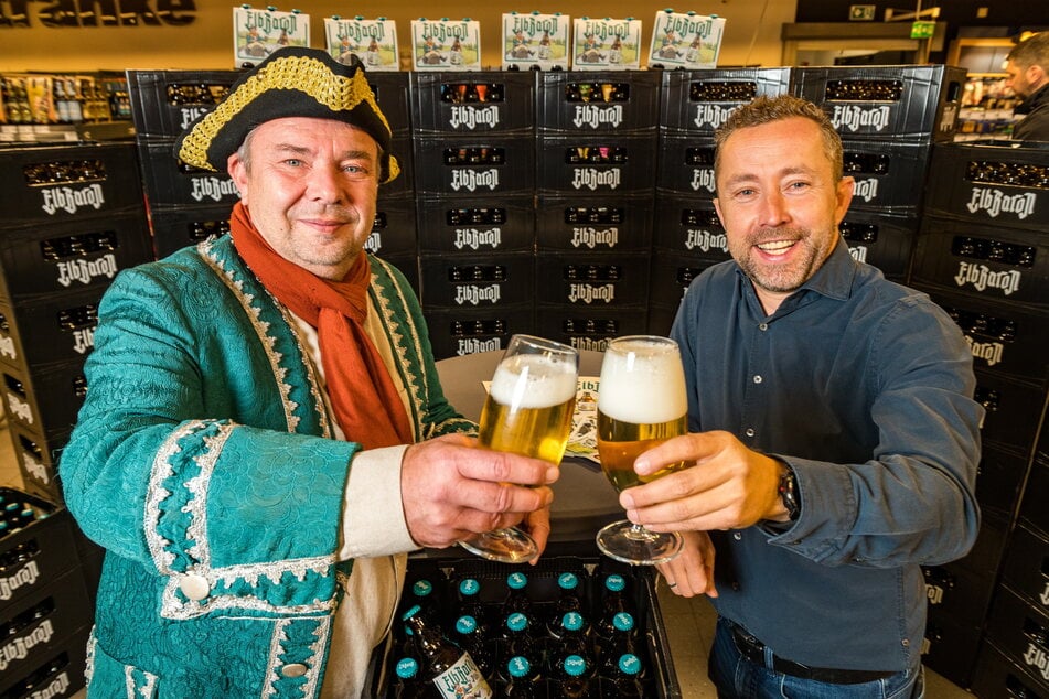 Der "ElbBaron" (Peter Splitt, 60) stößt mit Händler John Scheller (44, r.) im Edeka-Markt auf der Hamburger Straße auf die neue Biermarke an.