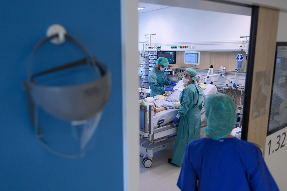 Intensivpfleger sind in der Corona-Intensivstation des Universitätsklinikums Dresden mit der Versorgung von Patienten beschäftigt.