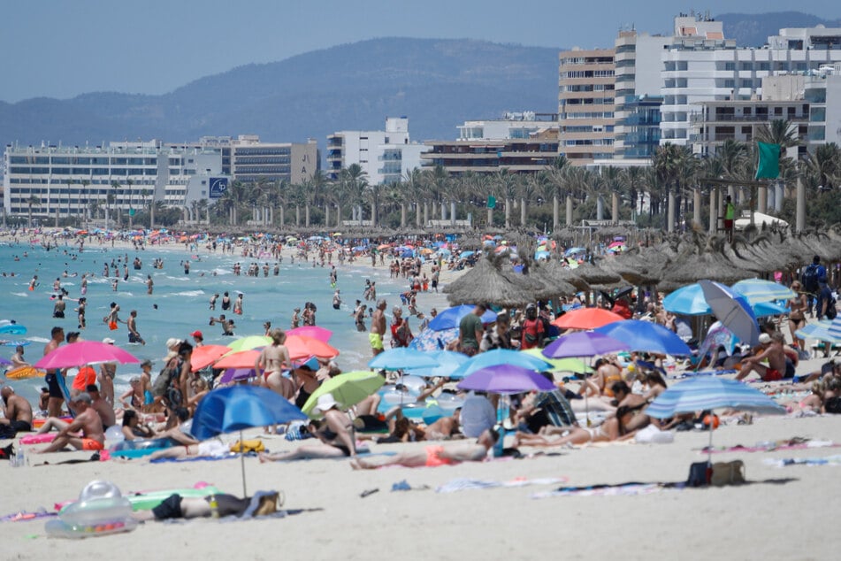 Palma de Mallorca im Juli 2021: Touristen genießen die Sonne am Strand von Arenal.