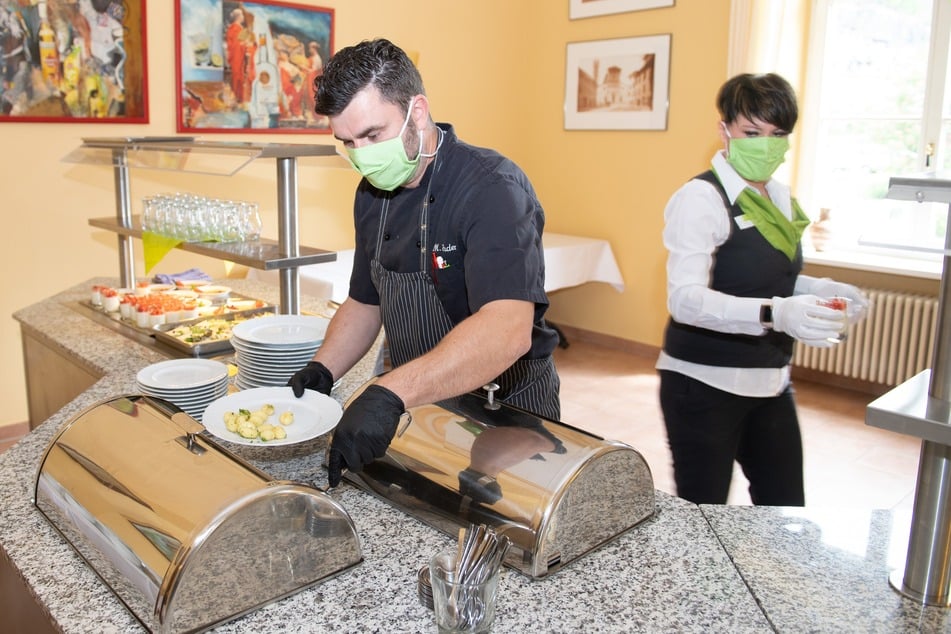 Manuel Enders, Küchenchef, und Mareen Funke, Restaurantleiterin, portionieren im Restaurant des Parkhotel Bad Schandau die Speisen.