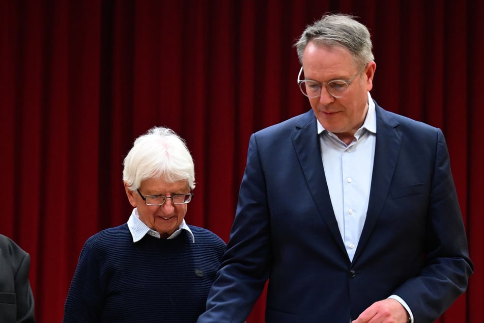 Ministerpräsident Alexander Schweitzer wirft seinen Stimmzettel in die Box. Links von ihm steht Alfred Burckhardt, stellvertretender Wahlleiter vom Wahlkreis 103 in Bad-Bergzabern.