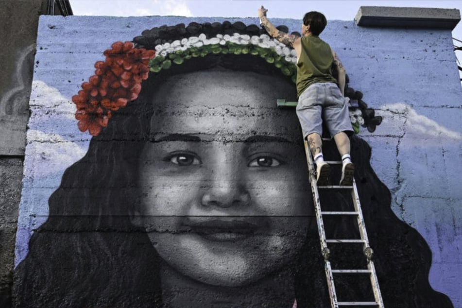 Artist Emmalene Blake completes a mural of Hind Rajab, the 5-year-old Palestinian girl who was killed in Gaza, in Dublin, Ireland.