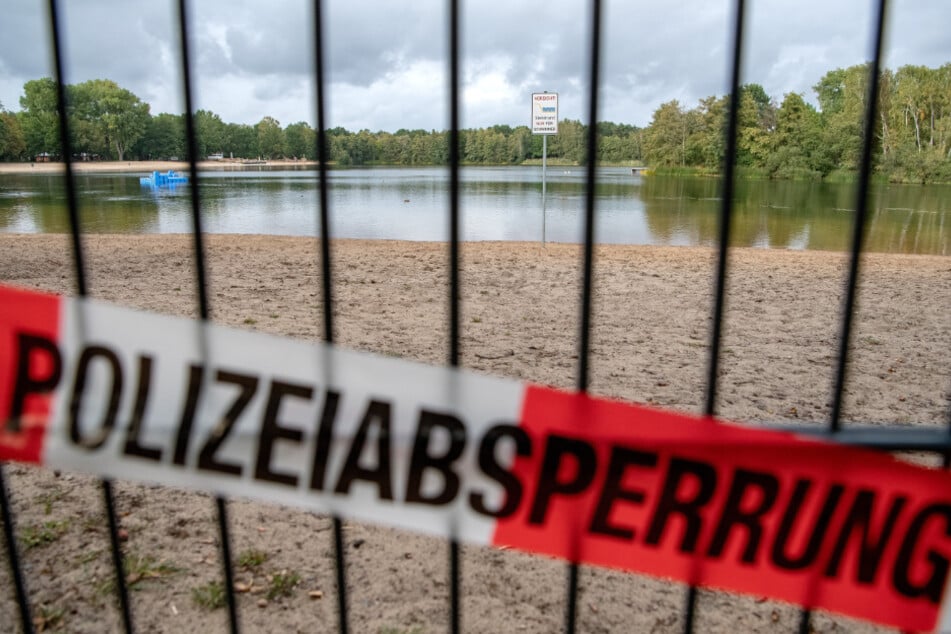 Ein Strandabschnitt eines Sees ist mit Flatterband der Polizei abgesperrt. (Symbolbild)