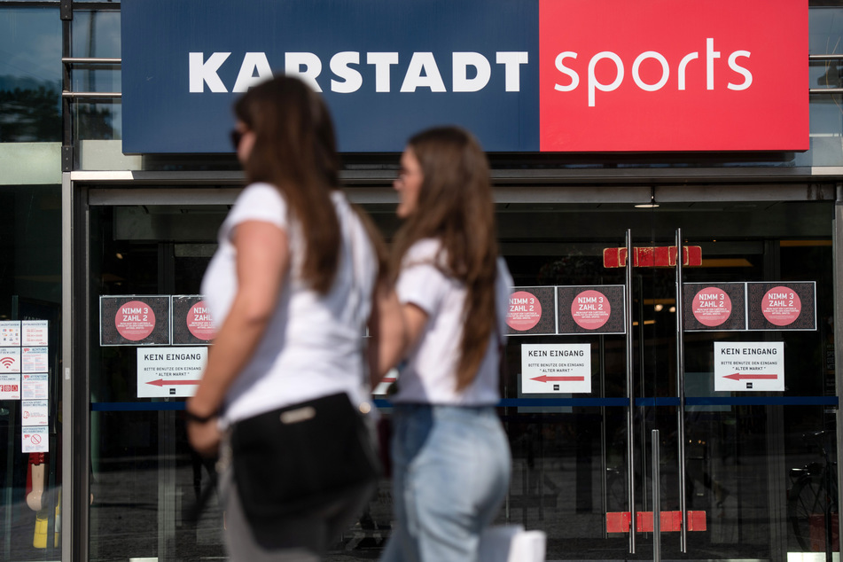 Passanten vor einer Filiale von Karstadt Sports.