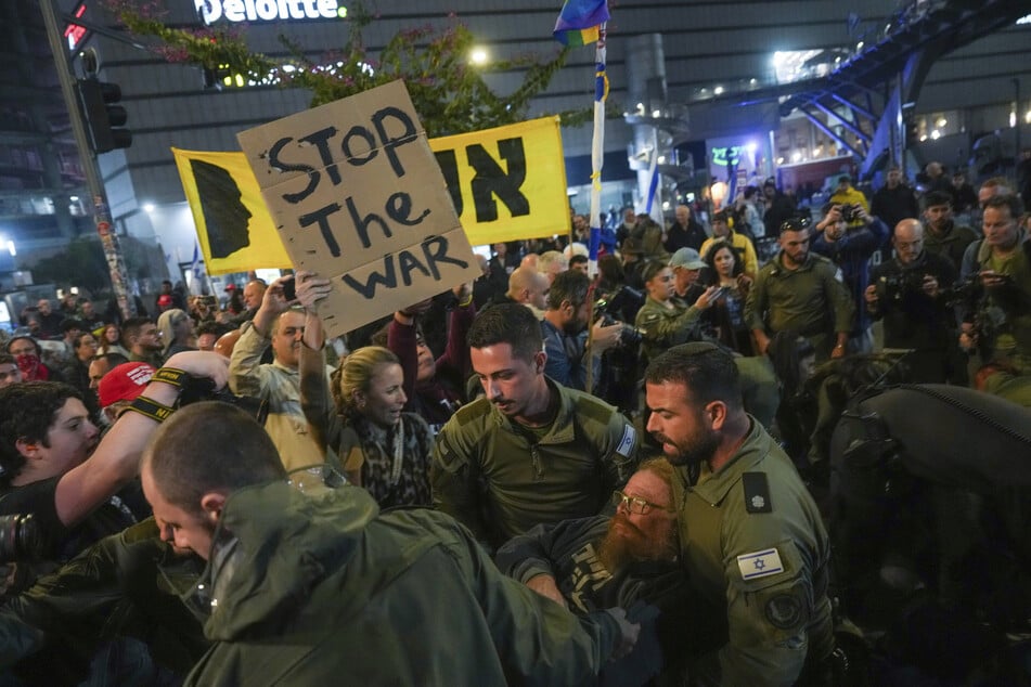 Polizisten ringen mit Demonstranten, die eine Straße blockieren, während einer Demonstration, die ein Waffenstillstandsabkommen und die sofortige Freilassung von Geiseln fordert, die im Gazastreifen von der Hamas festgehalten werden.