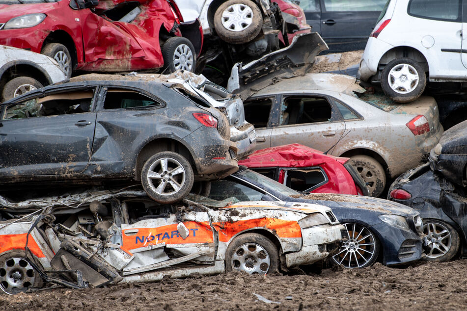 Beim Unwetter zerstörte Autos sind in Bad Neuenahr-Ahrweiler auf einem provisorischen Schrottplatz gestapelt.