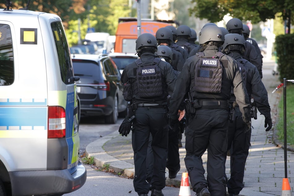 Spezialkräfte gehen durch den abgesperrten Bereich in der Lerchenau.