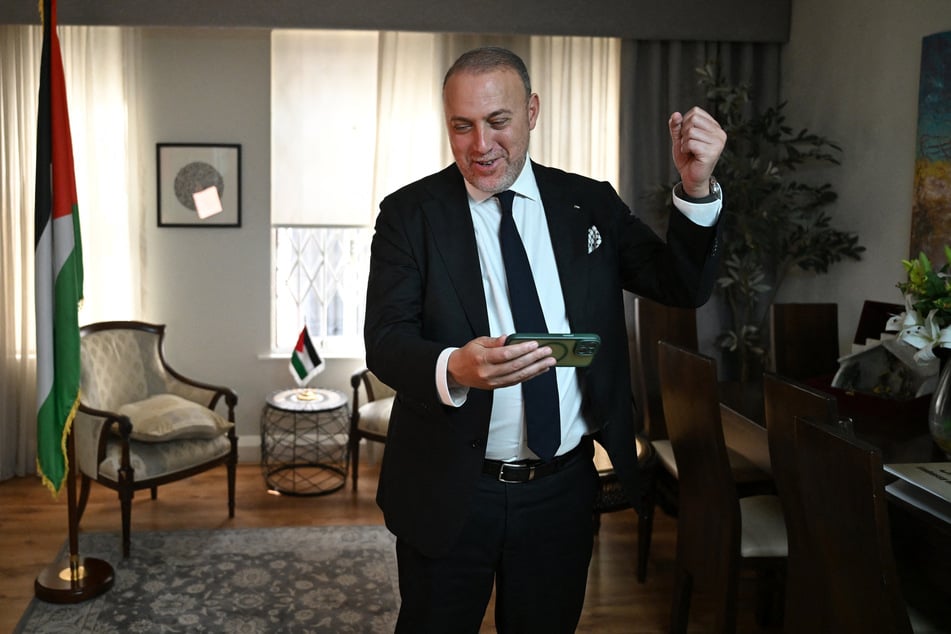 Head of the Palestine Mission to the UK Husam Zomlot celebrates upon hearing the news of the trilateral recognition of a Palestinian state.