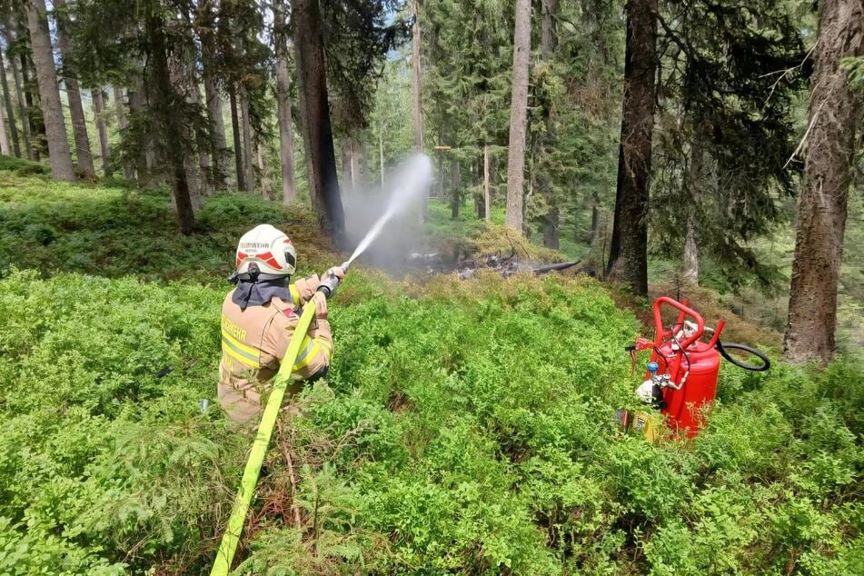 Einsatzkräfte der Feuerwehr löschten den kleinen Brand rund um den Absturzort.