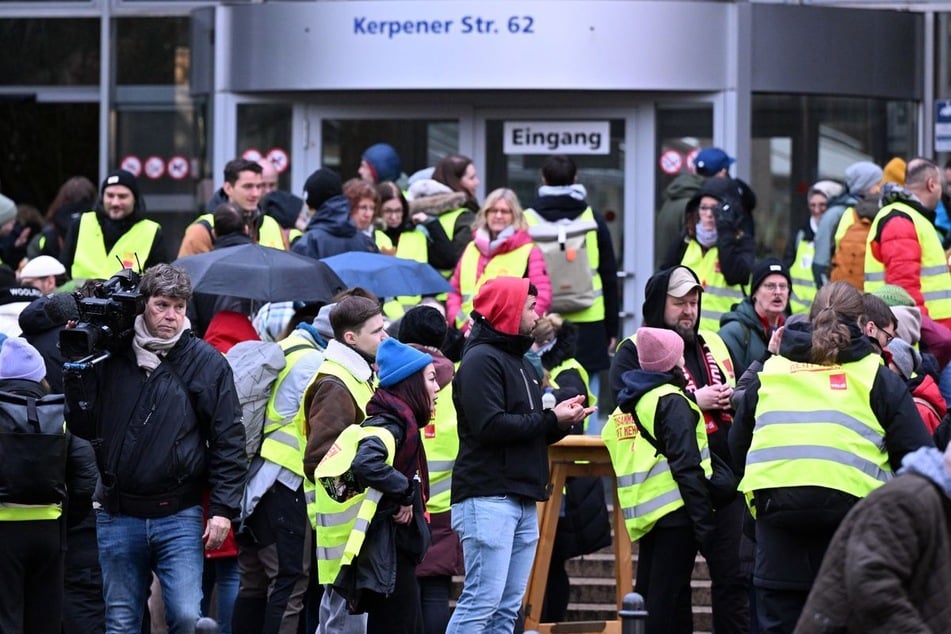 Beschäftigte der Uniklinik stehen bei einem Warnstreik vor dem Haupteingang.