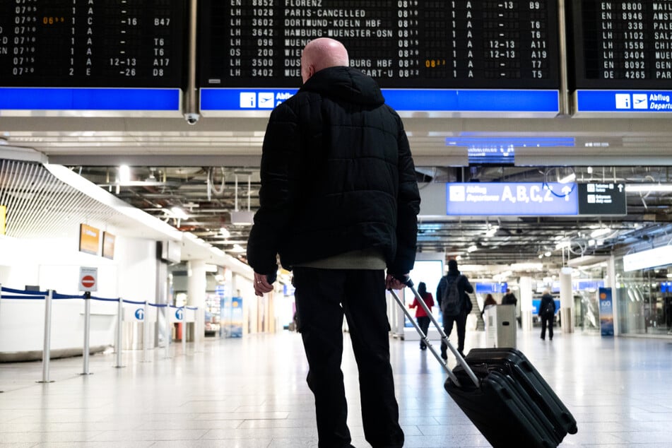 Ein Reisender schaut am Donnerstagmorgen am Frankfurter Flughafen auf eine Anzeigetafel mit zum Teil annullierten Flügen: Mehr als 5000 Piloten wurden zur Arbeitsniederlegung aufgerufen.
