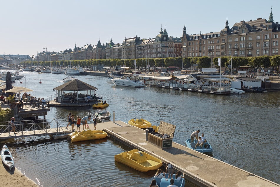 Bei den jährlichen Mittsommerfeierlichkeiten sitzen Menschen in Restaurants und fahren in Tretbooten. Schwedens öffentliche Mittsommerfeiern sind in diesem Jahr verhalten, da große gesellschaftliche Zusammenkünfte aufgrund der andauernden COVID-19-Pandemie verboten sind.
