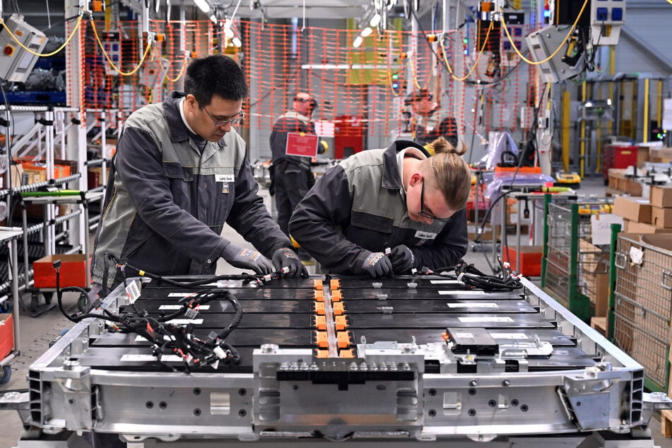 Zwei Opel-Mitarbeiter montieren in Eisenach Batterien für den Opel Grandland electric.